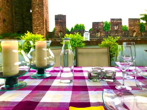 uma mesa com óculos e velas numa toalha de mesa xadrez em CA' DEL SOLE - Attico Panoramico in Centro Storico em Montagnana