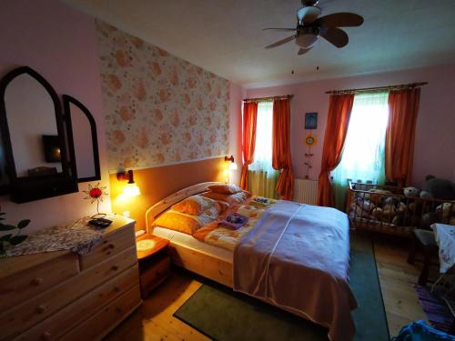 a bedroom with a bed and a dresser with a fan at Katica Vendégház Somogyvár - Ladybird Villa Somogyvár in Somogyvár