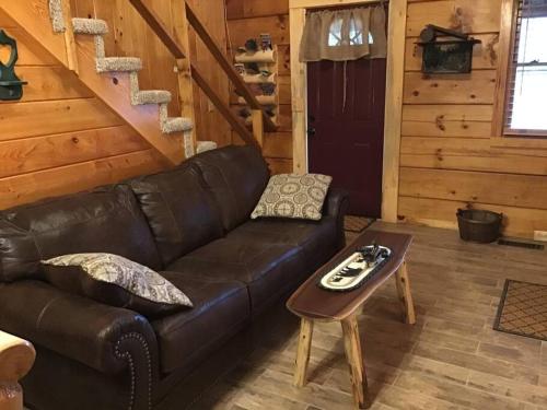 ein Wohnzimmer mit einem Ledersofa und einem Tisch in der Unterkunft Dollywood! Brand new Dancing Bear 3-Bear Tracks in Pigeon Forge