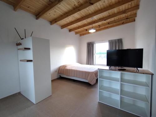 Schlafzimmer mit einem Bett und einem Flachbild-TV in der Unterkunft Coralillos in Puerto Madryn