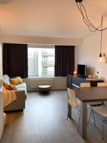 a living room with a couch and a table at Studio Delfien in Oostduinkerke