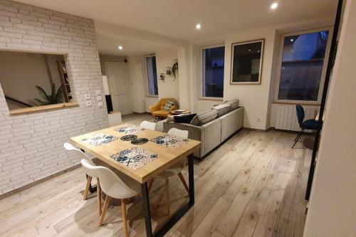 sala de estar con mesa y sofá en Maison tout confort centre de Nogent sur Seine en Nogent-sur-Seine