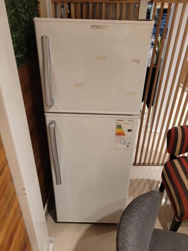 a white refrigerator in a room with a chair at Cabañas de Dario, Divino Tesoro in Alumbrera