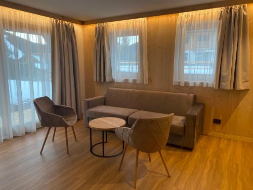 a living room with a couch and two chairs and a table at Les Ciases Chalets Dolomites in San Vigilio Di Marebbe