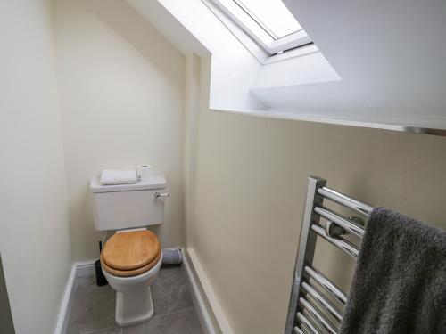 a bathroom with a toilet with a wooden seat at The Granary in Southam