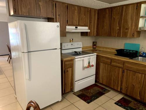 uma cozinha com um frigorífico branco e armários de madeira em Professor Rousseau's Tiki Hideaway em Crystal River