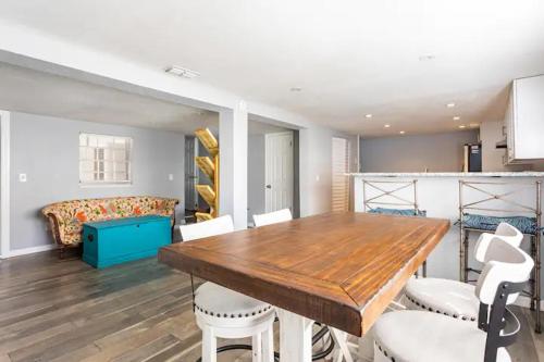 a dining room with a wooden table and white chairs at Heights Haven in Tampa