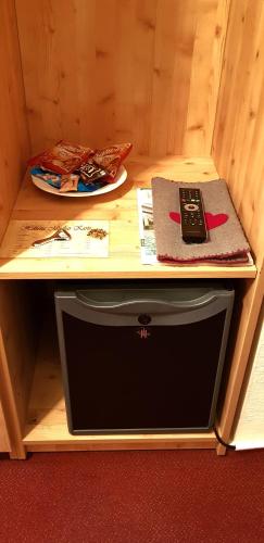 a table with a remote control sitting on top of a drawer at Villa Helvetia in Bad Elster