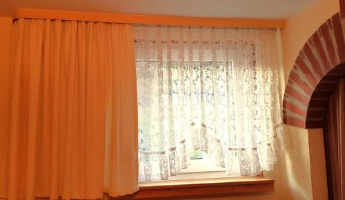 a window with an orange curtain in a room at Villa Helvetia in Bad Elster