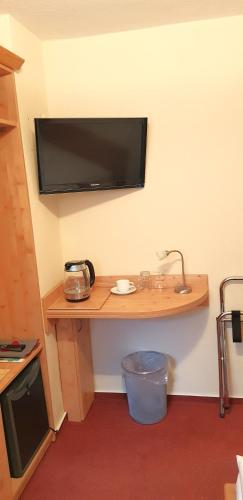 a room with a desk with a television on the wall at Villa Helvetia in Bad Elster