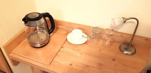 a counter with a coffee maker on a wooden table at Villa Helvetia in Bad Elster
