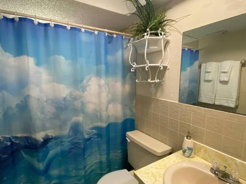 uma casa de banho com uma cortina de chuveiro azul e um WC. em Professor Rousseau's Mermaid Lagoon em Crystal River