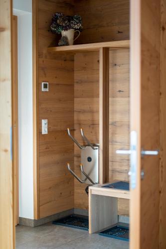 a room with a wooden wall with a shelf at Apartment LENA in Obertilliach