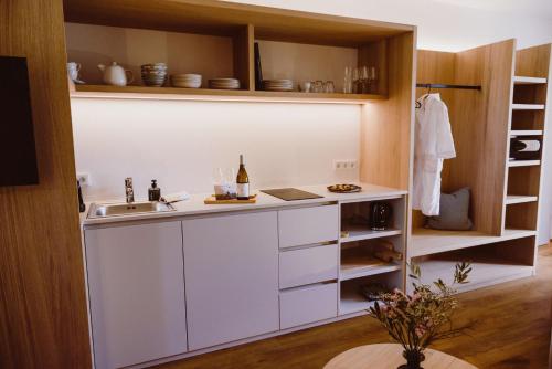 una cucina con armadi bianchi e lavandino di Achs-Wendelin Weinlofts a Gols