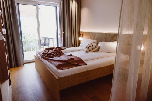 a bedroom with a bed with a large window at Achs-Wendelin Weinlofts in Gols