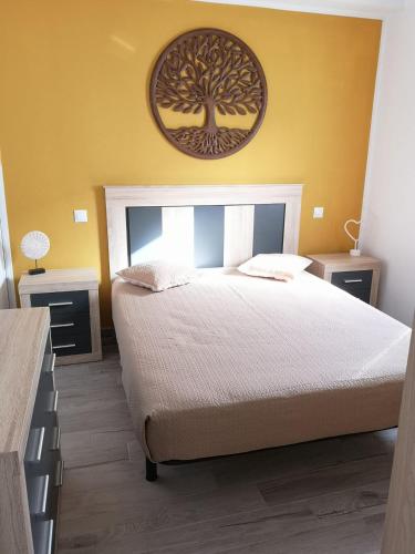 a bedroom with a bed with a tree picture on the wall at Estrella de Mar in Tarajalejo