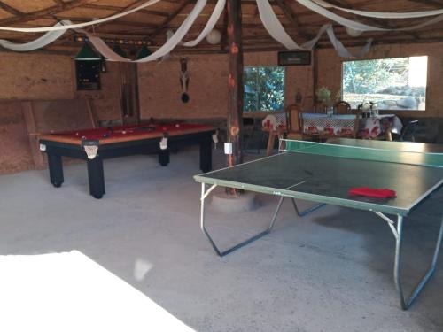 dos mesas de ping pong en una habitación con un pongetivo de ping pong en Cabaña Don Pepe, en Estancia Don Domingo, en Curicó