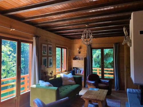 Chalet Les Airelles في Montcel: غرفة معيشة مع أريكة خضراء وطاولة