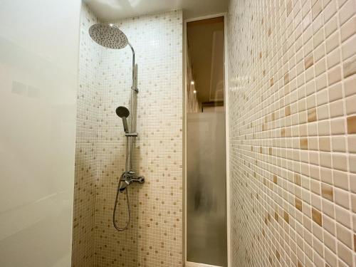 a shower in a bathroom with a tile wall at Studio at Synagogue with Sauna in Budapest