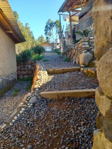 a stone walkway next to a house with a stone wall at Estancia Don Domingo in Hualañé