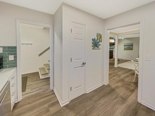 um corredor com uma porta branca e uma escada em 5 Min to Beach—King Beds em Charleston