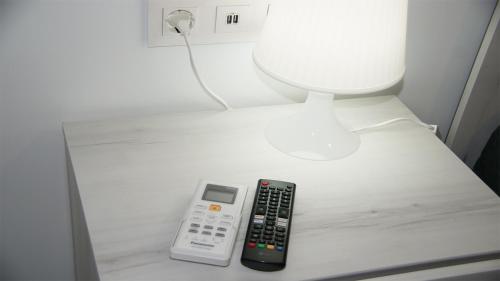 un mando a distancia sentado en una mesa junto a una lámpara en Luxury Bungalow Costa Blanca Ground Floor ,Torrevieja, Lago Jardin 1, en Torrevieja