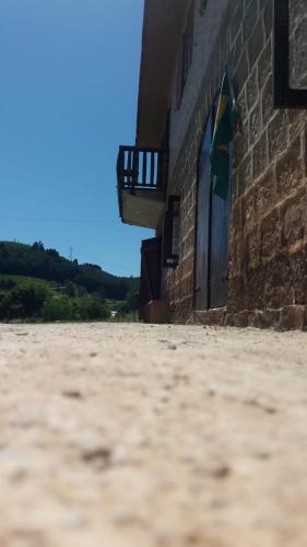a building with a stone floor next to a brick wall at Casa de Campo Província Minosso in Farroupilha