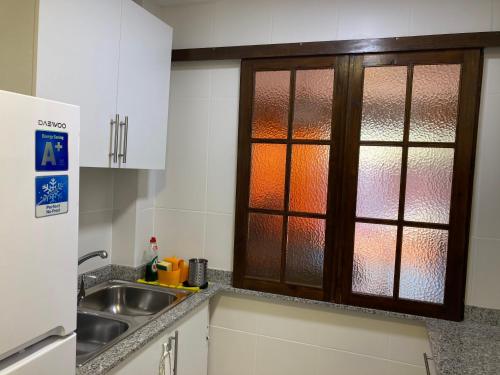 a kitchen with a sink and a glass window at Apartamento L'Estartit in L'Estartit