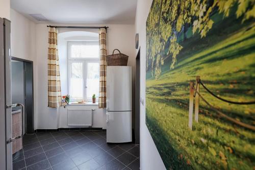 a kitchen with a refrigerator and a painting on the wall at Apartmány U Aloise in Dolní Morava