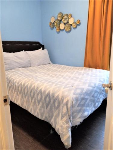 a bedroom with a bed and a blue wall at Niagara Getaway in Niagara Falls