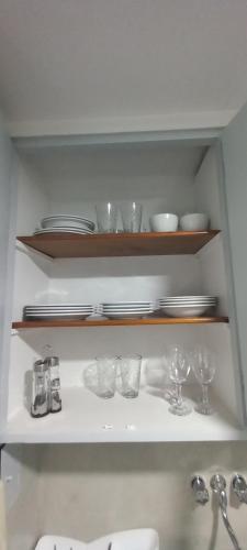 a shelf with plates and glasses and plates on it at Departamento en Recoleta in Buenos Aires