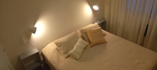 1 dormitorio con 1 cama con sábanas y almohadas blancas en Departamento en Recoleta en Buenos Aires