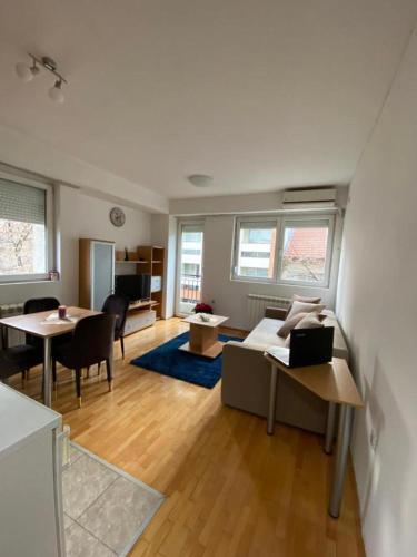 a living room with tables and chairs and a living room at Tea Apartment in Skopje