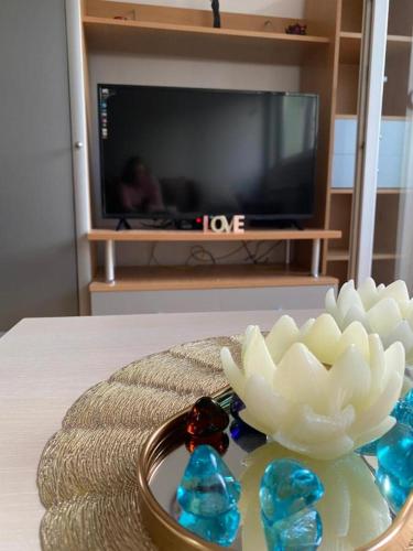 a bowl of crystals on a table in front of a tv at Tea Apartment in Skopje