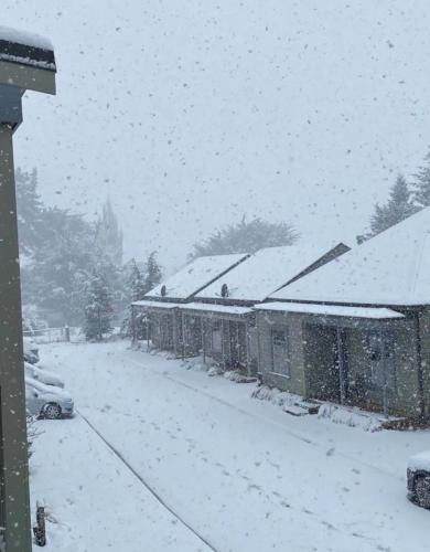a house covered in snow in a yard at Cardrona Villa with Pool and Jacuzzi in Cardrona