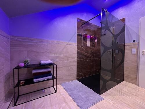 uma casa de banho com um chuveiro com iluminação roxa em A&D Apartment+Ferienwohnung/Elsasser Blick em Bühlertal