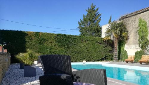 uma piscina com cadeiras ao lado de uma cerca em Charme au cœur des vignes em Malras