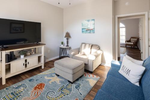 sala de estar con TV, sofá y silla en Coquina Casita en Myrtle Beach