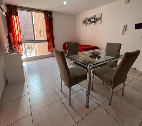 a dining room with a glass table and chairs at Departamento Lima B General Paz con Pileta in Cordoba