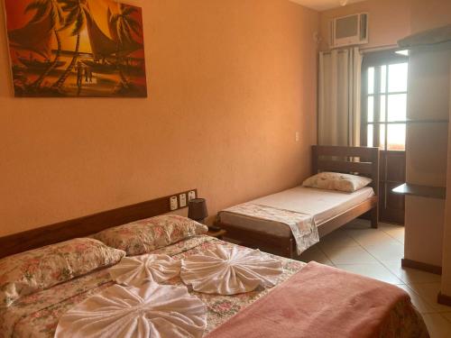 a room with two beds and a window at Pousada Maravista in Anchieta