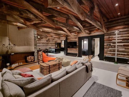 ein großes Wohnzimmer mit einem großen Sofa und Stühlen in der Unterkunft Villa Uuttu in Kuusamo