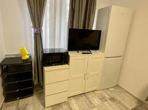 a living room with a tv on a white cabinet at City center - Unirii studio in Bucharest