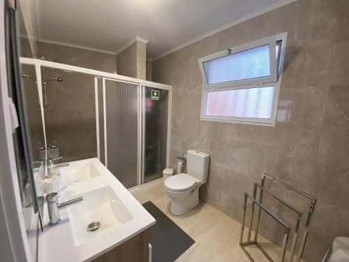 a bathroom with a sink and a toilet and a window at Casa da Ribeira - Mosteiros in Mosteiros