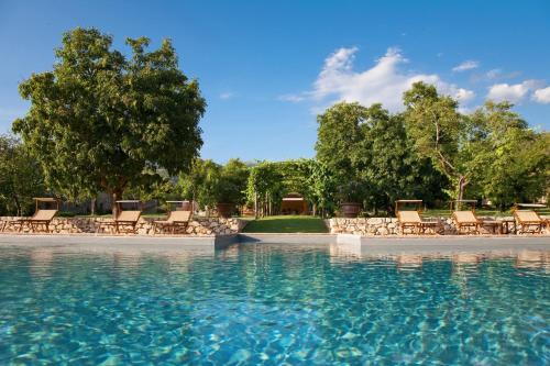 uma piscina de água com cadeiras e árvores em Borgo Della Marmotta em Spoleto