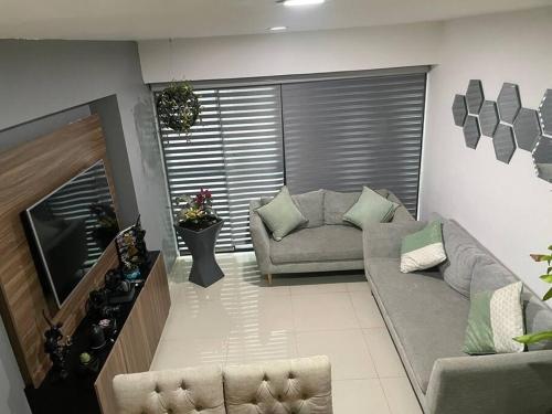 a living room with a couch and a television at Departamento cerca del Aeropuerto y Foro sol in Mexico City