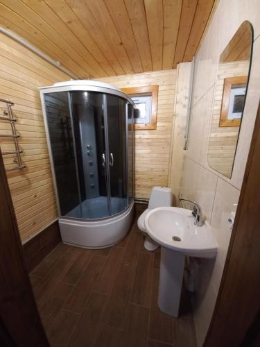 a small bathroom with a shower and a sink at На горі in Vorokhta