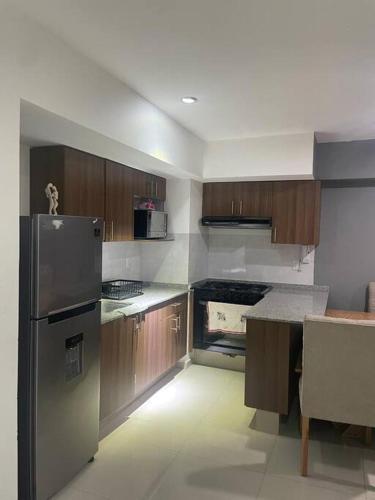a kitchen with wooden cabinets and a stainless steel refrigerator at Departamento cerca del Aeropuerto y Foro sol in Mexico City