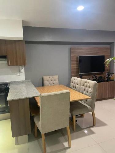 a kitchen with a wooden table with chairs and a television at Departamento cerca del Aeropuerto y Foro sol in Mexico City