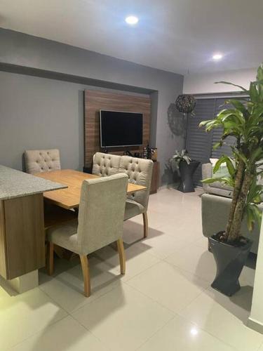 a dining room with a table and chairs and a tv at Departamento cerca del Aeropuerto y Foro sol in Mexico City