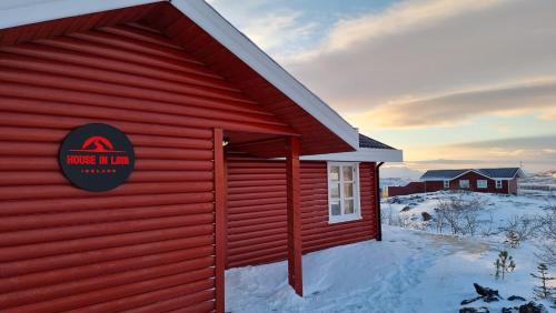 a red building with a sign on the side of it at House in lava in Bifrost